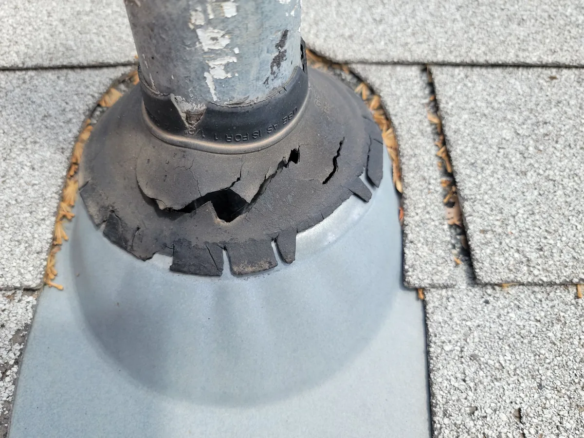 Cracked rubber pipe boot around a vent pipe, the kind of wear roof inspections look for