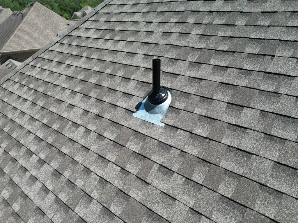 New pipe boot flashing sealed around a vent pipe on a shingle roof after roof leak repair